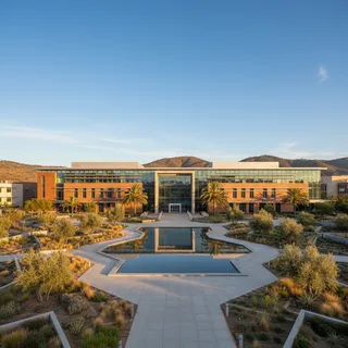 Modern school exterior with landscaped grounds under a sunny sky, architectural photography style.